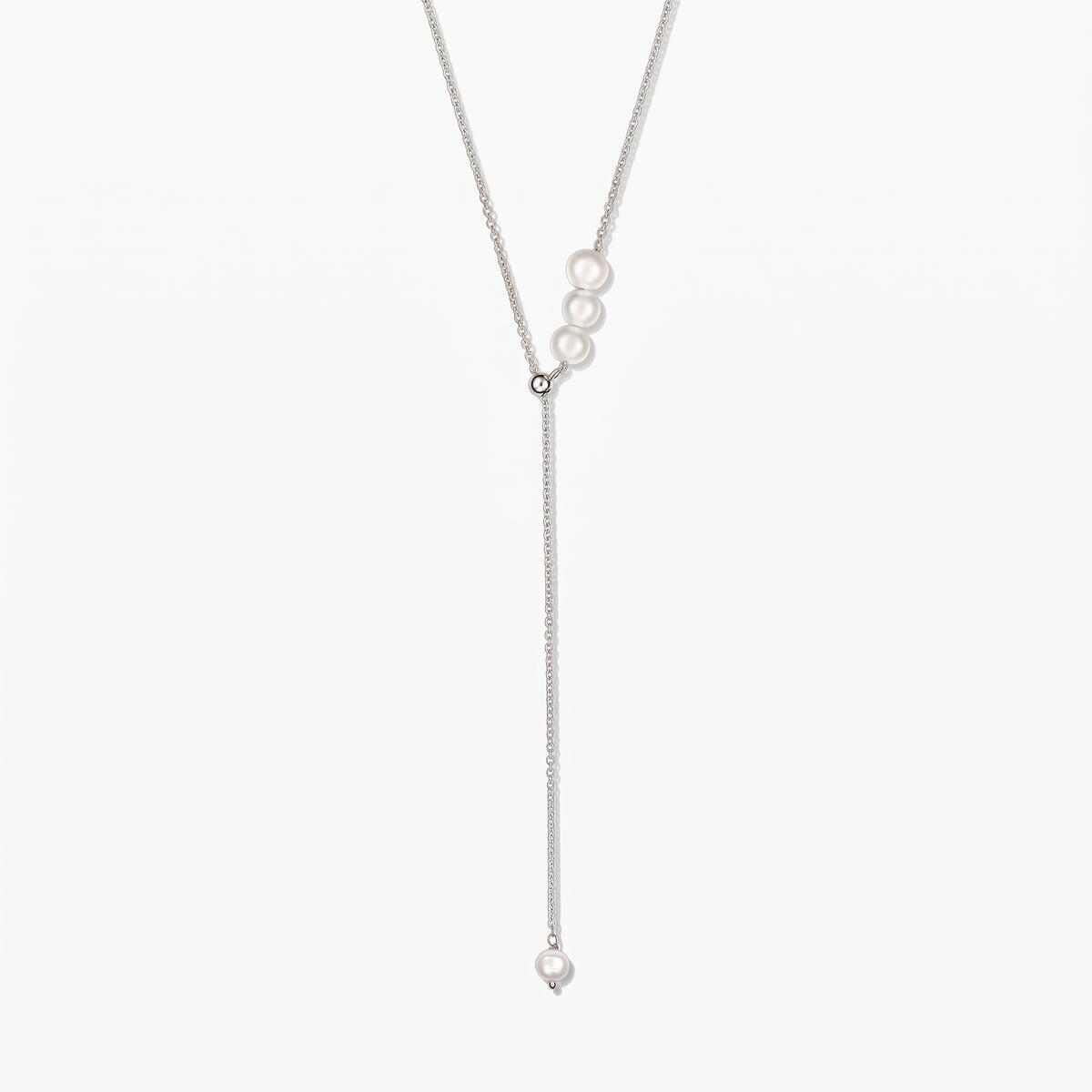 Verstellbare Lariat-Halskette aus Sterlingsilber mit weißen Zuchtperlen, zentriert auf weißem Hintergrund.