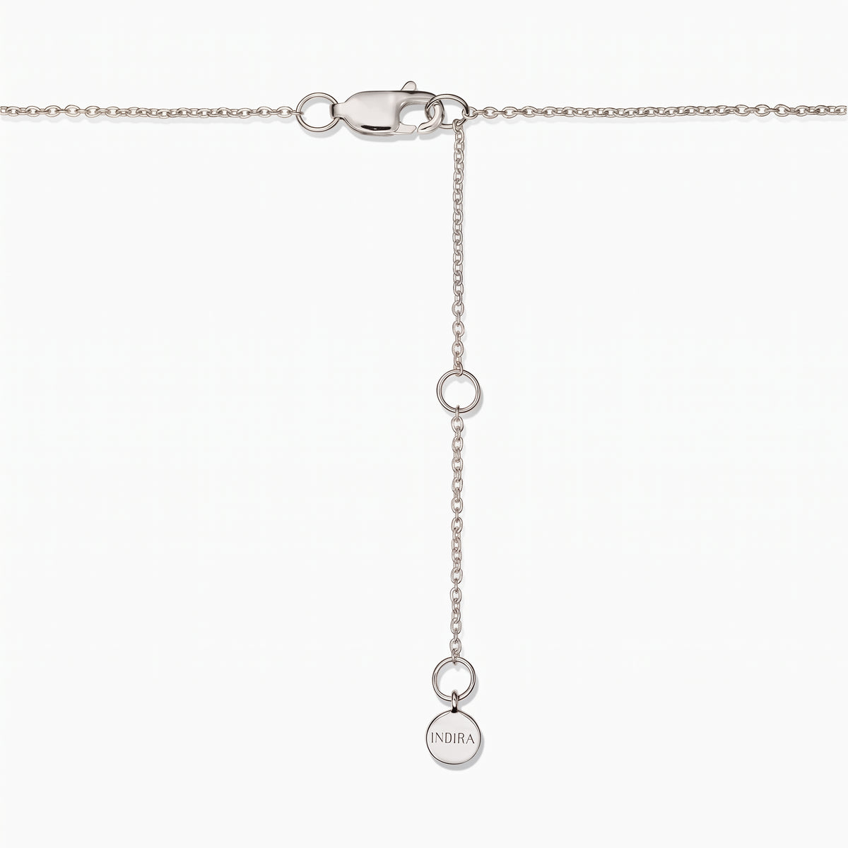 Nahaufnahme eines Halskettenverschlusses aus Sterlingsilber mit verstellbarer Verlängerungskette und kleinem rundem Indira-Plättchen auf weißem Hintergrund.