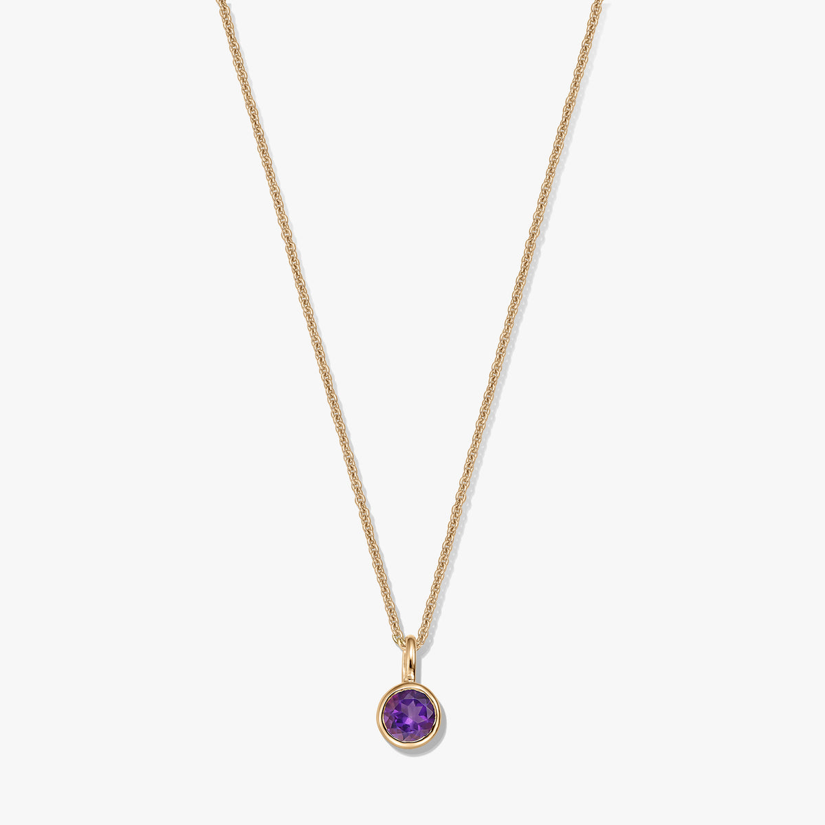 Vergoldete Halskette aus Sterlingsilber mit kleinem, rundem Amethyst-Geburtsstein-Anhänger vor weißem Hintergrund.