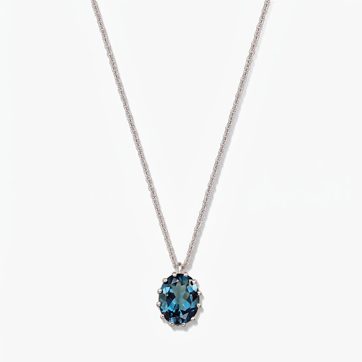 Sterlingsilber-Halskette mit ovalem London Blue Topas-Anhänger vor weißem Hintergrund.