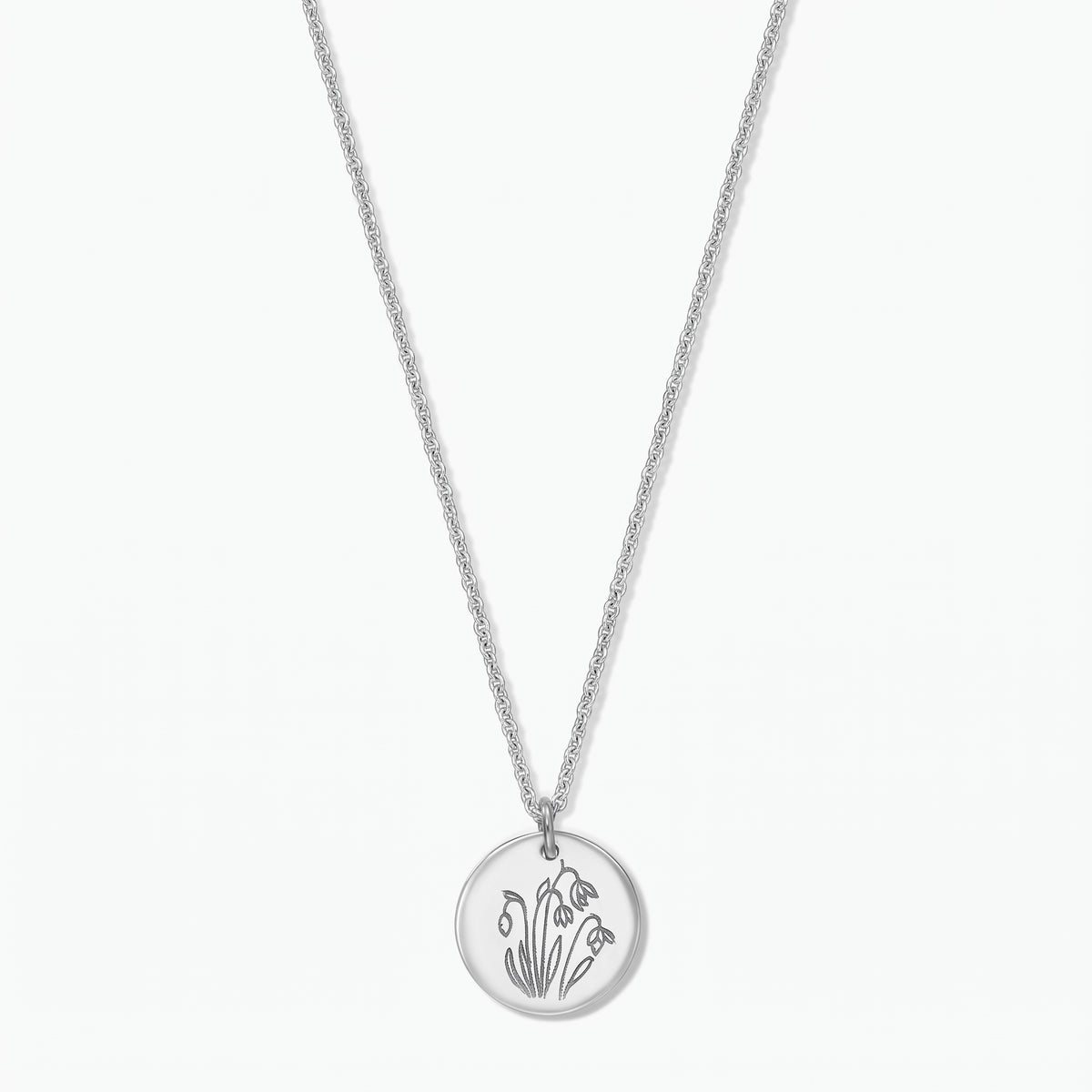 Elegante Sterlingsilber-Halskette mit Geburtsblume: runder Scheibenanhänger, graviert mit Januar-Schneeglöckchen, an einer feinen Kette, freigestellt vor weißem Hintergrund.