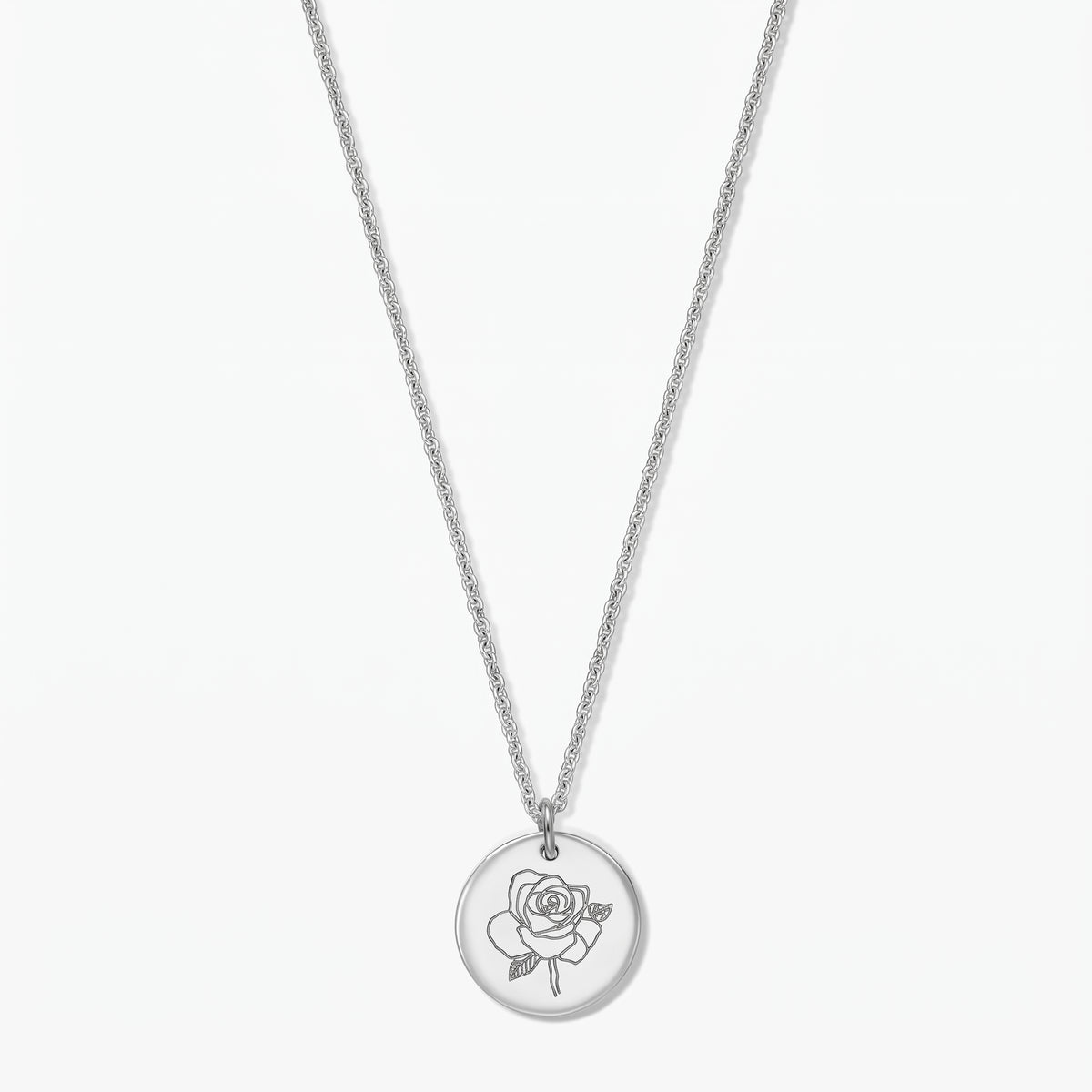 Geburtsblumen-Halskette aus Sterlingsilber mit rundem Anhänger, graviert mit einer Rose (Juni), vor weißem Hintergrund fotografiert.