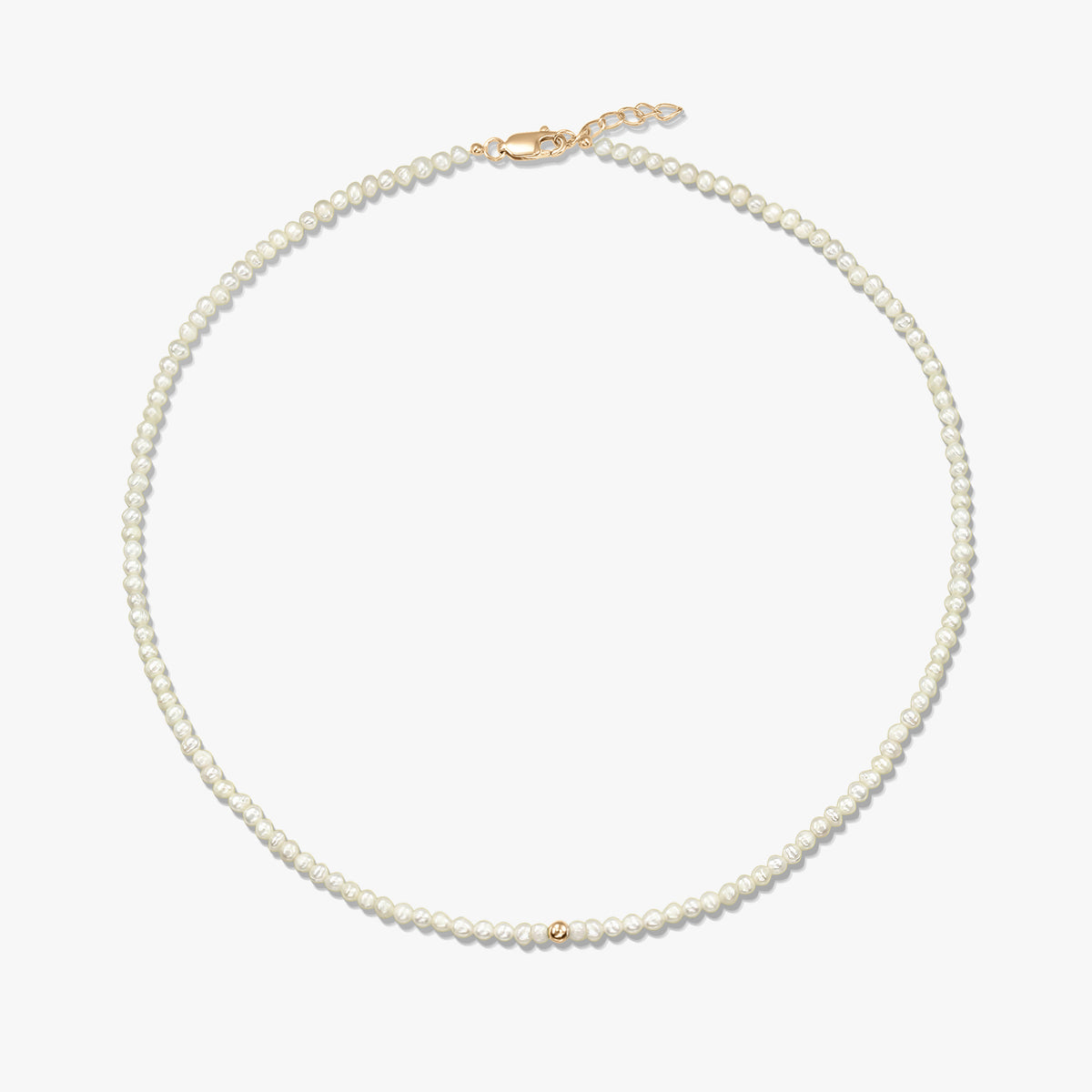 Quadratisches Produktbild einer zarten Halskette aus natürlichen Perlen mit einer kleinen 14K-Gelbgold-Perle als Akzent und einem gelbgoldenen Karabinerverschluss mit kurzem Verlängerungskettchen, vor weißem Hintergrund.