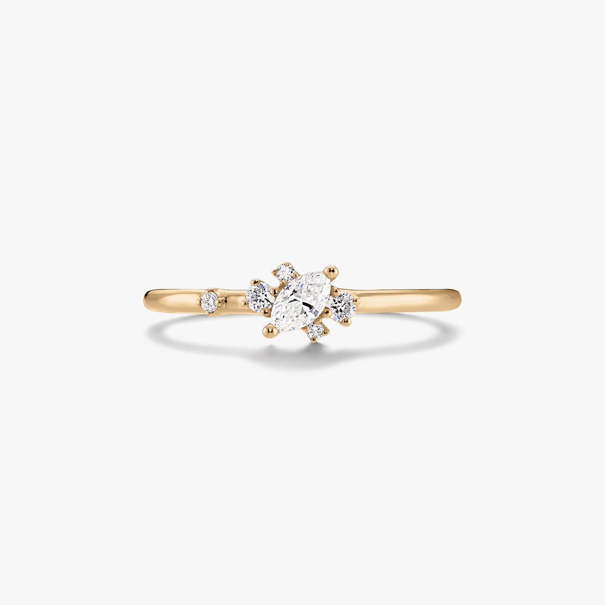 Dünner 14K-Gelbgoldring mit mittig gefasstem Diamanten im Marquise-Schliff und kleinen runden Akzentdiamanten auf weißem Hintergrund.