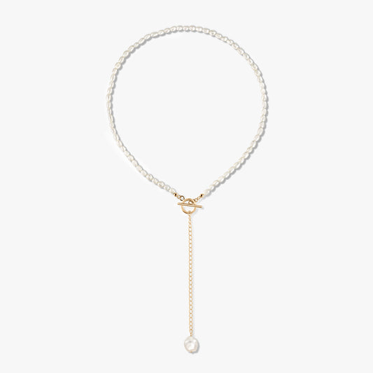 Golden Jacqueline 14K gold‑plated sterling silver pearl necklace with front toggle clasp and a gold drop chain ending in a single pearl, on a white background.