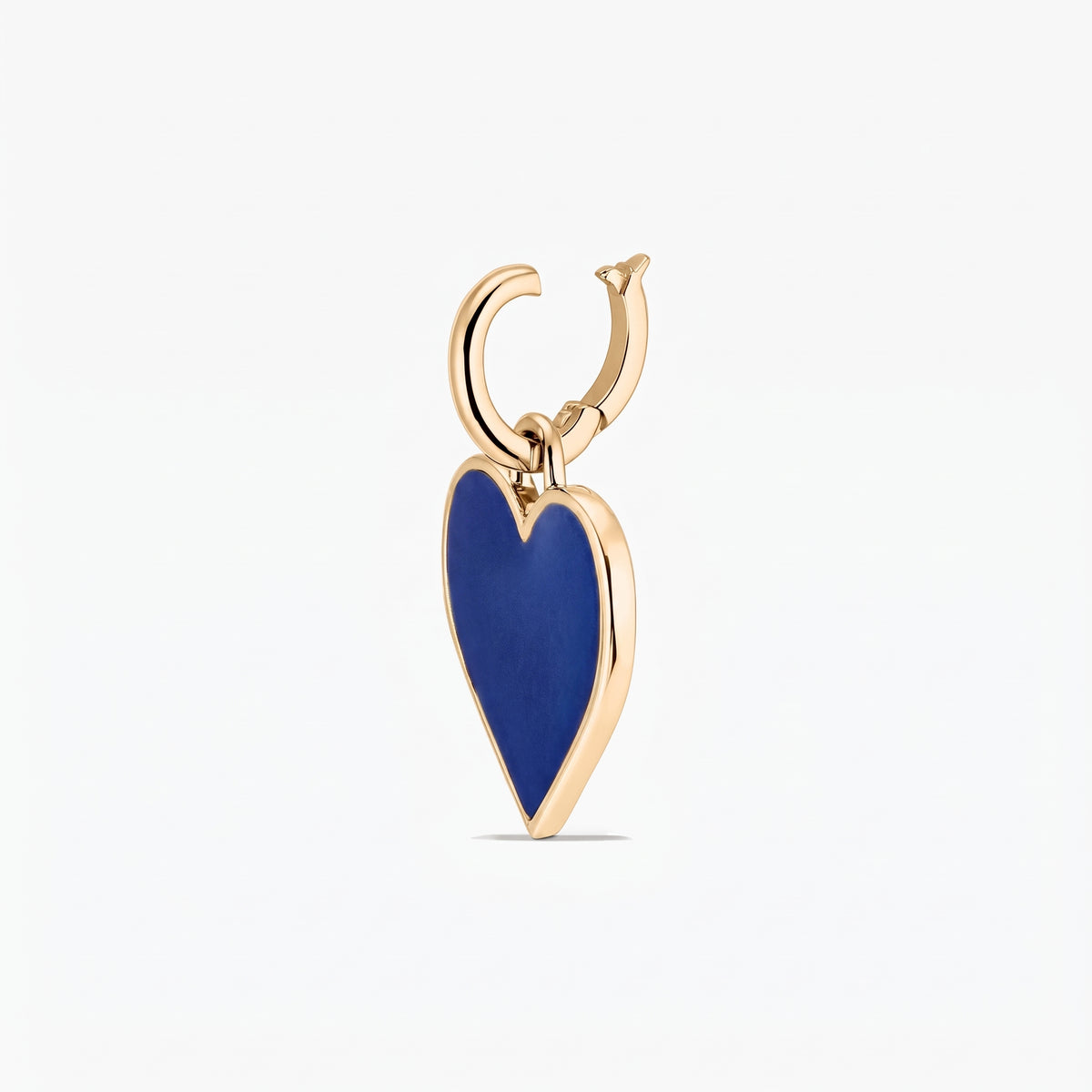 Nahaufnahme eines silbernen Anhängers mit einem tiefblauen Herzanhänger, umrahmt von einer goldfarbenen Kante, isoliert vor weißem Hintergrund.