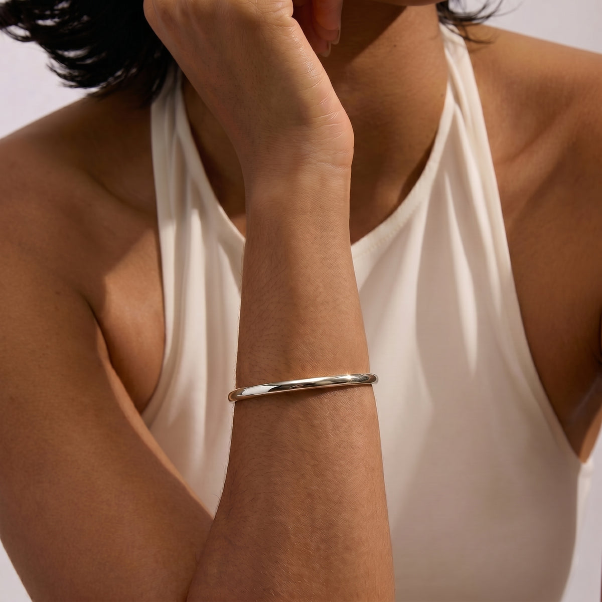 Nahaufnahme einer Person mit dem eleganten Serena Silver Bracelet am Arm vor schlichtem Hintergrund.