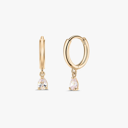 Pair of 14K yellow gold huggie hoop earrings with dangling pear-cut white zirconia drops on a white background.
