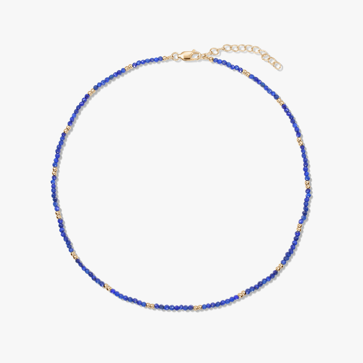 Zarte Halskette aus Lapislazuli-Perlen mit kleinen Akzenten aus vergoldetem Sterlingsilber und verstellbarem Karabinerverschluss, freigestellt vor weißem Hintergrund.