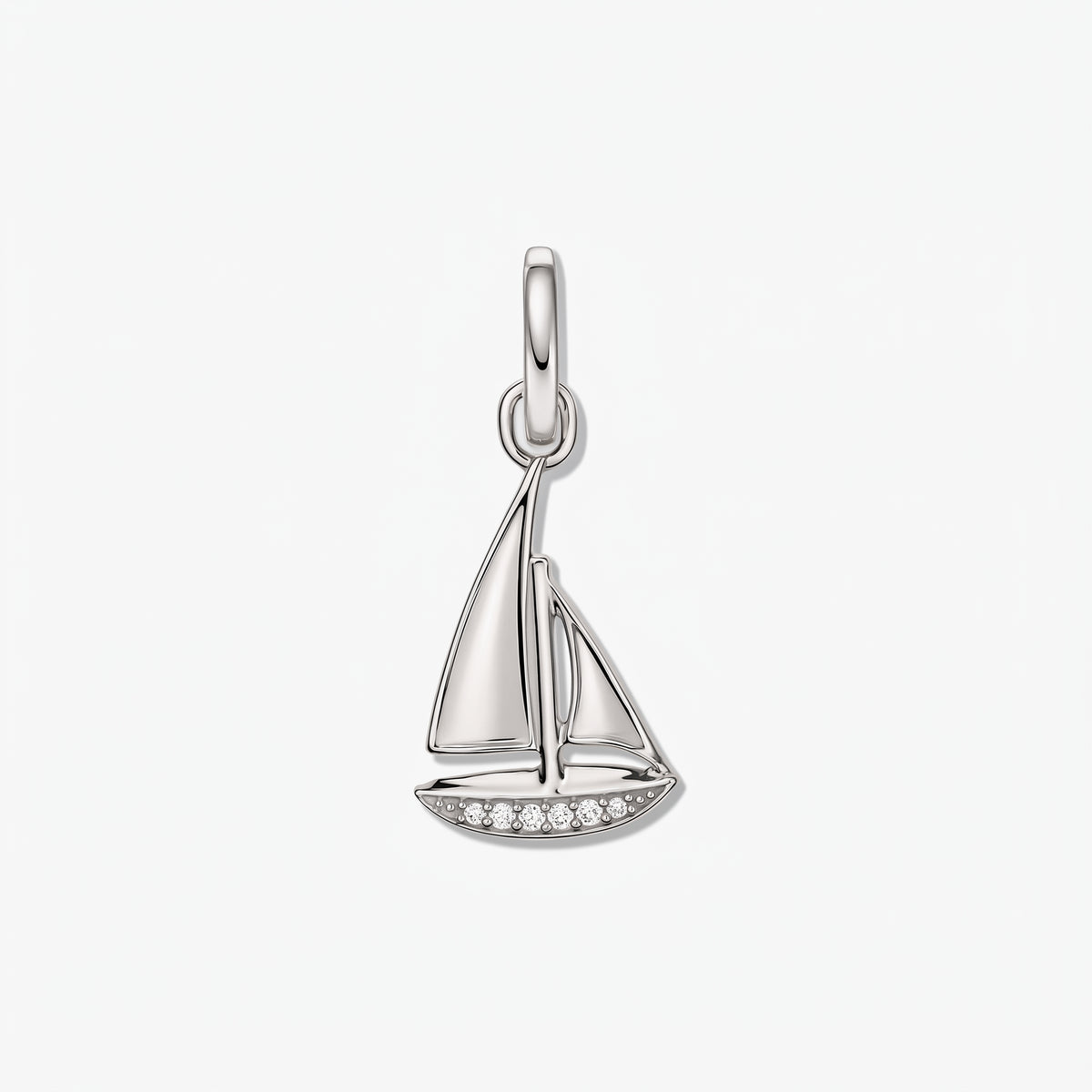 Anhänger eines Segelboots aus Sterlingsilber mit kleinen weißen Zirkonia-Akzenten vor weißem Hintergrund.