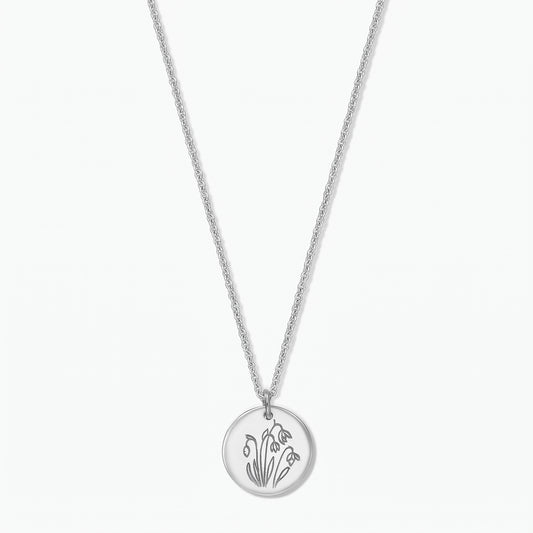Elegante Sterlingsilber-Halskette mit Geburtsblume: runder Scheibenanhänger, graviert mit Januar-Schneeglöckchen, an einer feinen Kette, freigestellt vor weißem Hintergrund.