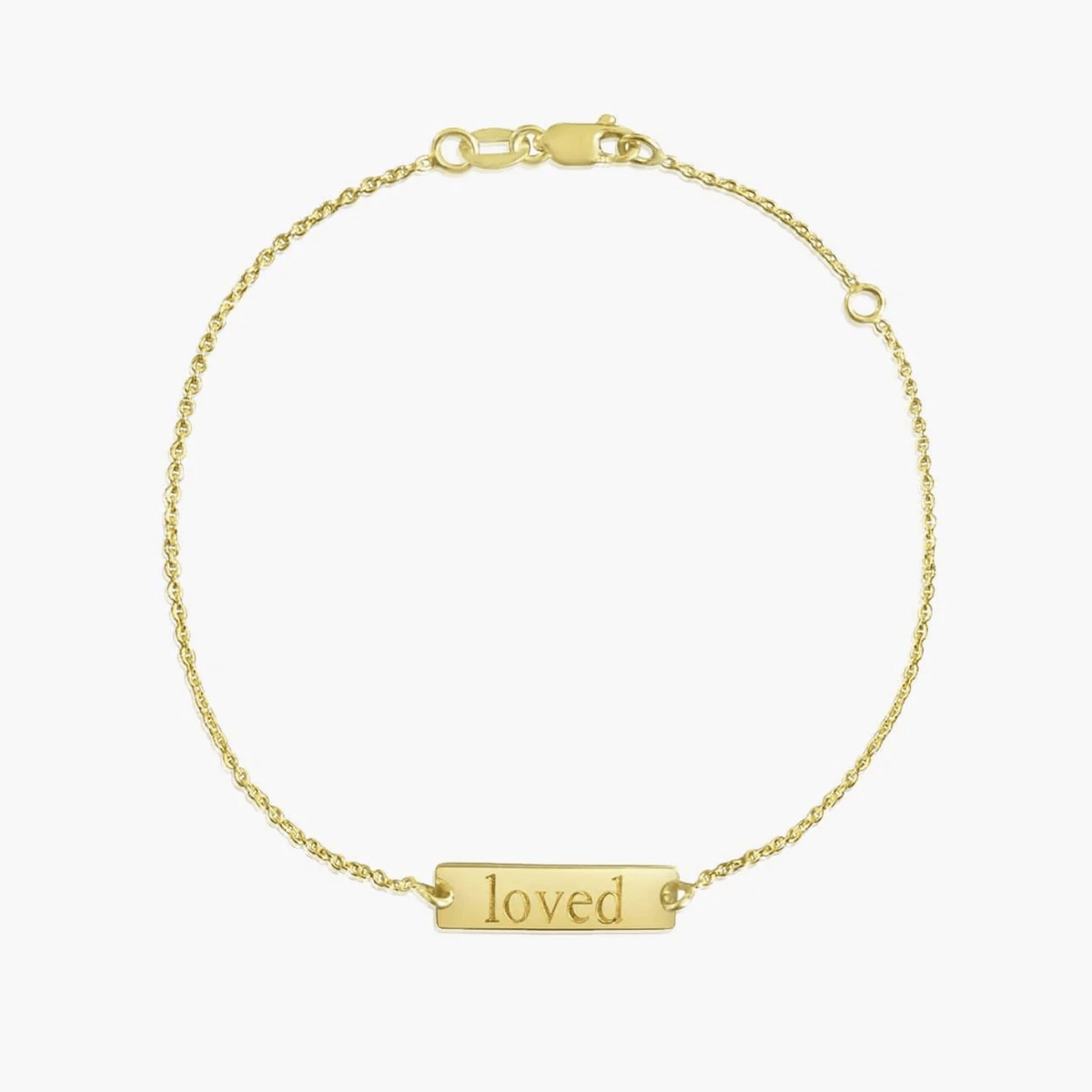 14K-Goldarmband mit der Gravur ‚loved‘ vor reinweißem Hintergrund.